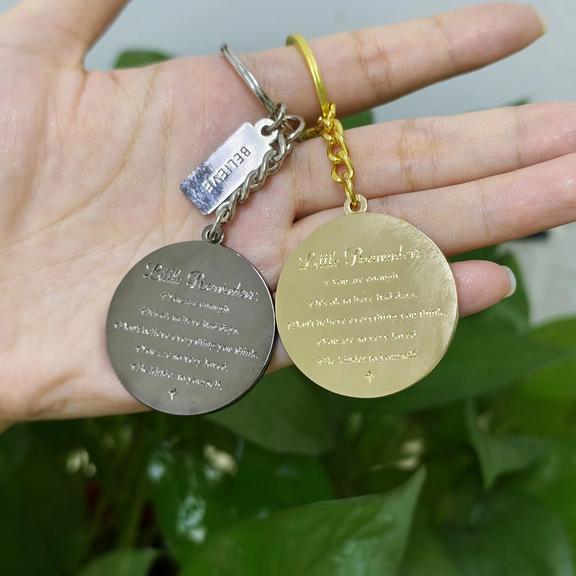 Real life Gold and Charcoal keychains back view in hand